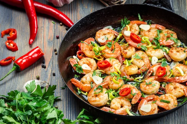 Freshly fried shrimps with herbs on old pan — Stock Photo, Image