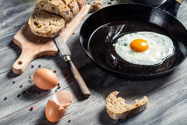 Крупный план свежеобжаренного яйца на сковороде — стоковое фото