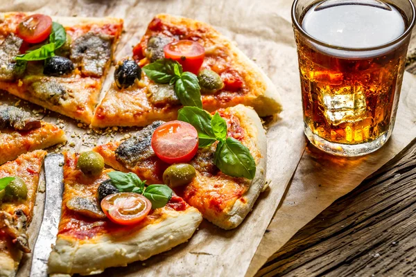 Freshly baked pizza served with a cold drink — Stock Photo, Image