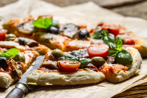 Closeup of baked pizza with olives and tomatoes — Stock Photo, Image