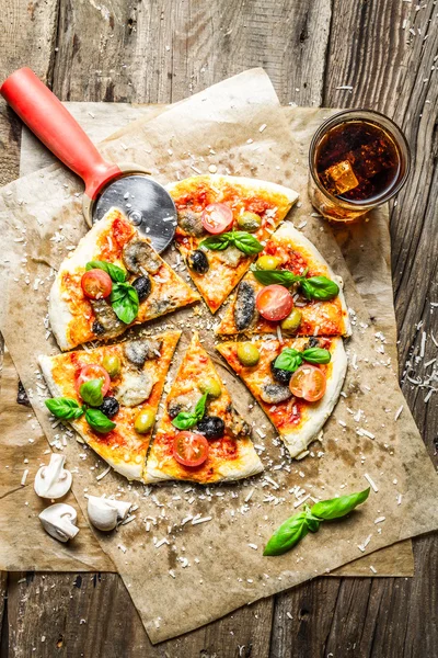 Cutting homemade pizza with basil — Stock Photo, Image