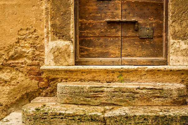Old wooden door with medieval wall background — Stock Photo, Image