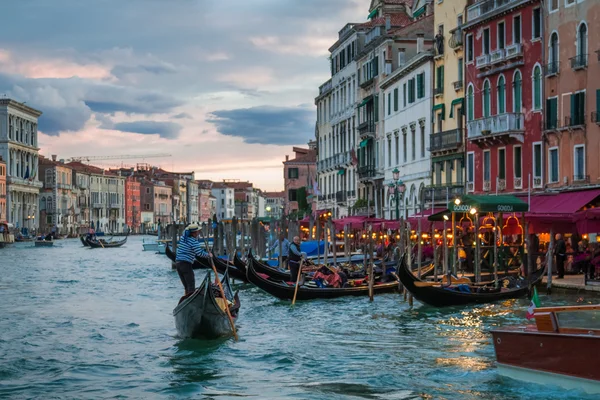 Gondelier drijvend in de buurt van restaurants in Venetië — Stockfoto