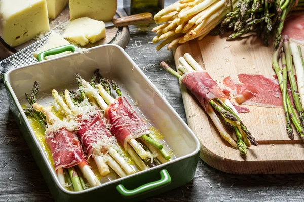 Preparation of asparagus wrapped in Parma ham with cheese