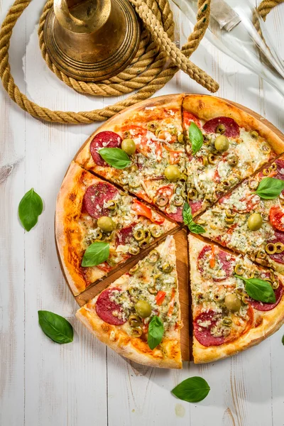 Fresh pizza with salami, olives and basil — Stock Photo, Image