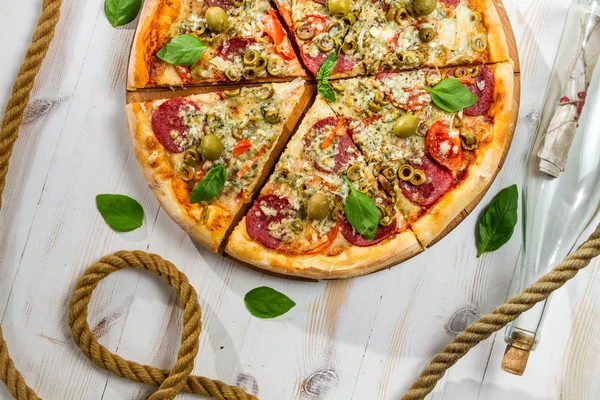 Pizza on a boat made of salami and olives — Stock Photo, Image