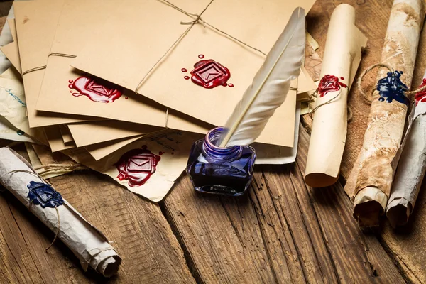 Closeup of blue inkwell and glasses on table filled with old mes — Stock Photo, Image