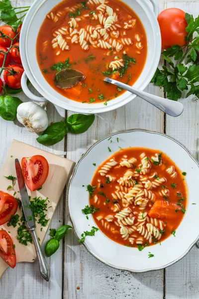 Tomatsoppa med nudel och ingredienser på gamla träbord — Stockfoto