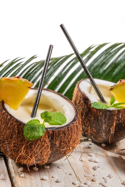 Pinacolada i en kokosnöt på gamla vita bord — Stockfoto