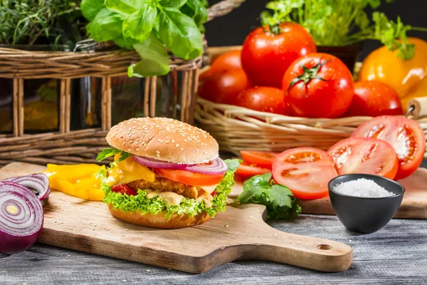 Hambúrguer com frango, tomate e legumes — Fotografia de Stock