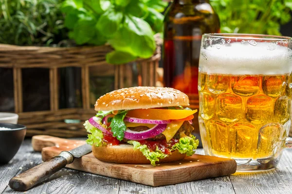 Primer plano de hamburguesa fresca y una cerveza fría — Foto de Stock