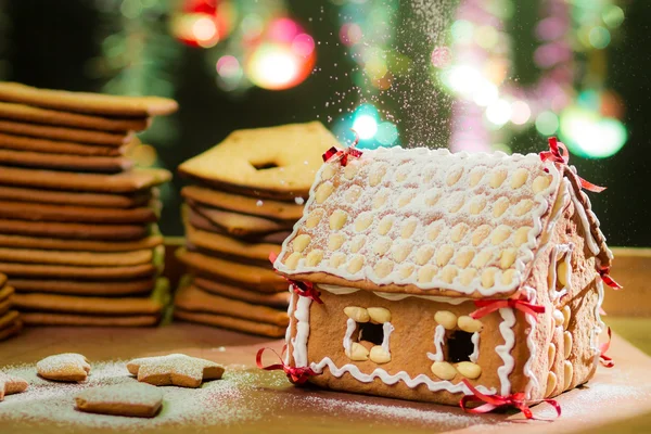 Lebkuchenhaus mit Puderzucker dekorieren — Stockfoto