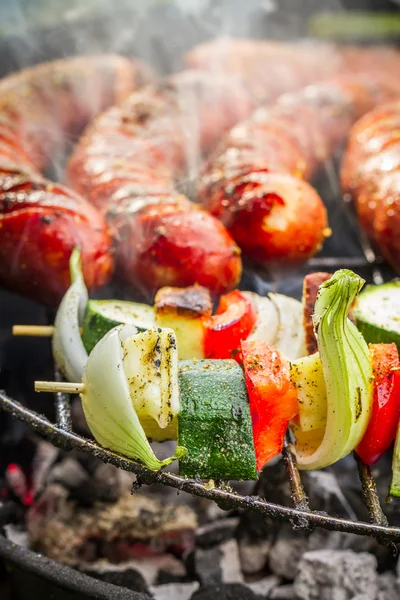Closeup of sausages and skewers on the grill — Stock Photo, Image