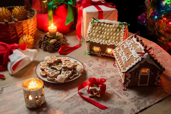 Cottage e biscotti di pan di zenzero sulla tavola di Natale — Foto Stock