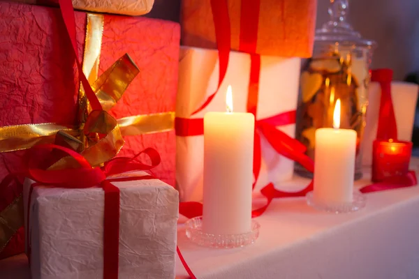 Primer plano de los regalos cerca de un árbol de Navidad a la luz de las velas — Foto de Stock