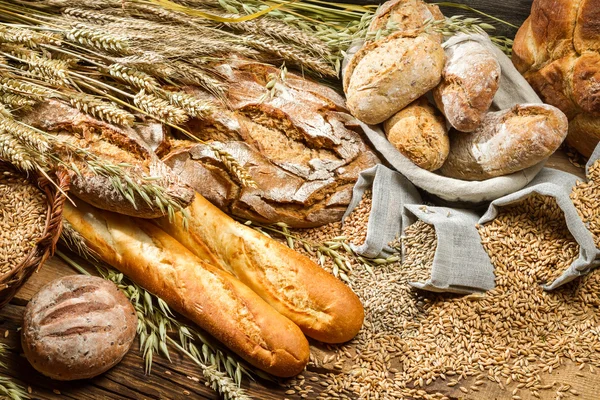 Цілий пшеничний хліб на старому дерев'яному столі — стокове фото
