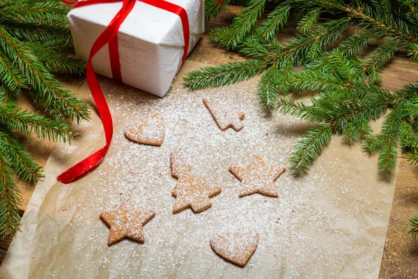 Shapes of gingerbread cookies on a piece of paper and icing suga — Stock Photo, Image