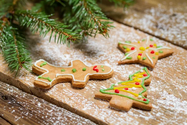 Pequeñas galletas de jengibre sobre mesa de madera con abeto — Foto de Stock