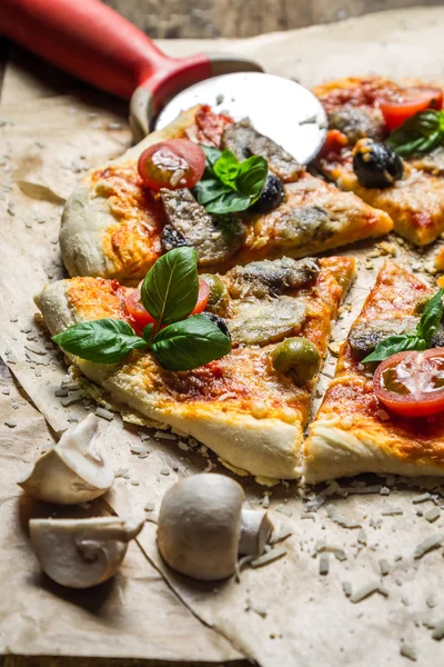 Snijden zelfgemaakte pizza op oude tabel — Stockfoto
