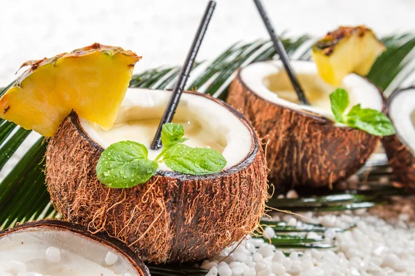 Pinacolada in a coconut on old white table — Stock Photo, Image