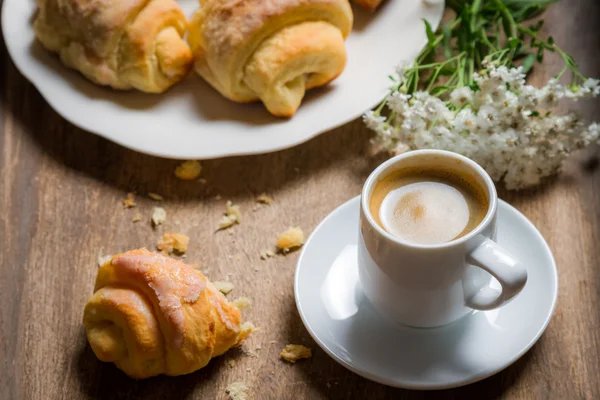 Blumen, Croissant und Kaffee zum Frühstück — Stockfoto