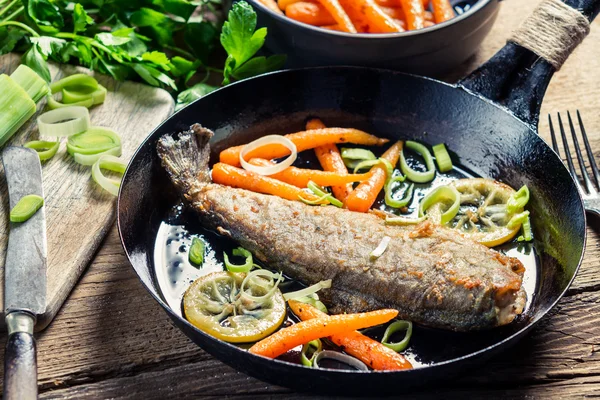 Primo piano di pesce appena fritto con porro e carota — Foto Stock