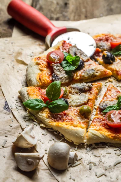 Cutting homemade pizza on old table — Stock Photo, Image