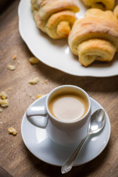 Frukost på sängen med espresso, blomma och croissant — Stockfoto