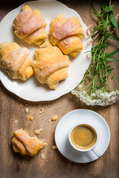 Ontbijt op bed met espresso, bloem en croissant — Stockfoto