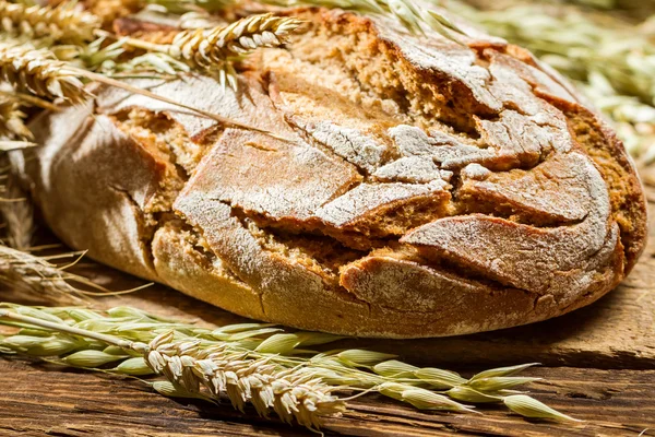 Closeup of wholemeal bread on old wooden table — Stock Photo, Image