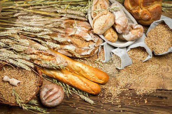 Teljes kiőrlésű kenyér, a régi fából készült asztal — Stock Fotó