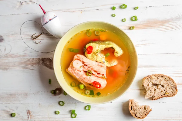 Salmon soup served with bread on old wooden table — Stock Photo, Image