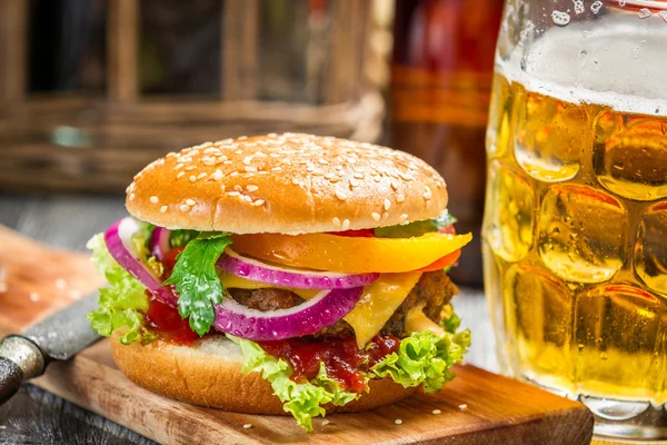 Closeup of fresh burger and a cold beer — Stock Photo, Image