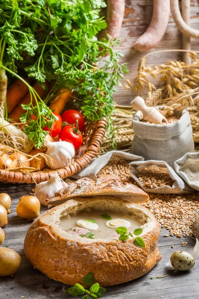 Sour soup with sausage and eggs served in bread — Stock Photo, Image