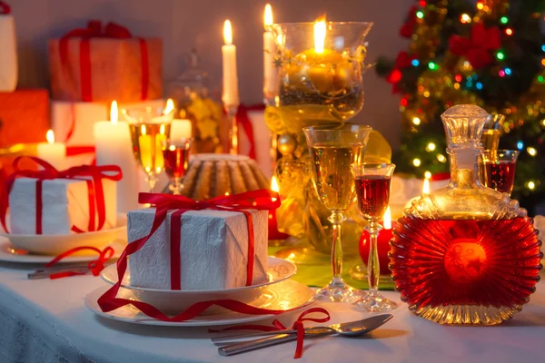 Luz de velas e presentes por toda a mesa de Natal — Fotografia de Stock