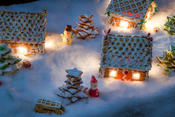 白雪皑皑的姜饼村庄与圣诞老人、 雪人和礼物 — 图库照片