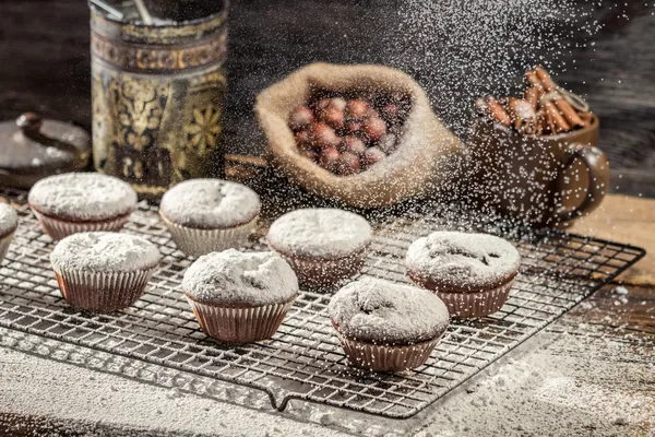 Close-up van vallen poeder suiker op chocolade muffins — Stockfoto
