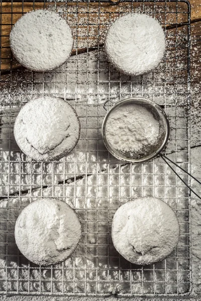 Крупный план падения сахара на свежие ванильные кексы — стоковое фото