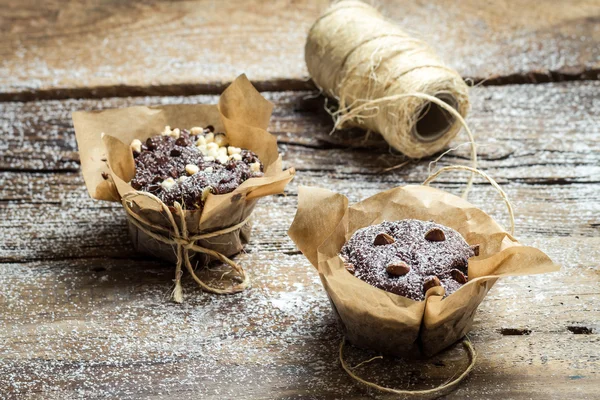 Decorating chocolate muffins with paper and string — Stock Photo, Image