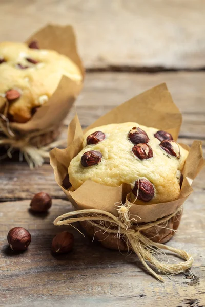 Gros plan de muffin à la vanille avec des noix enveloppées dans du papier — Photo