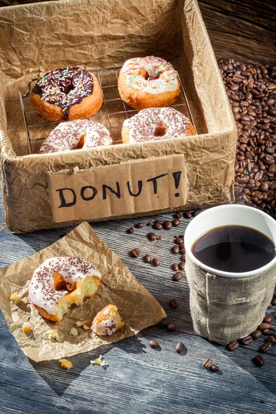 Scatola piena di ciambelle con caffè — Foto Stock