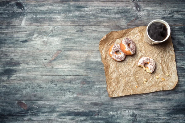 Donuts, coffee and wooden table background — Stock Photo, Image
