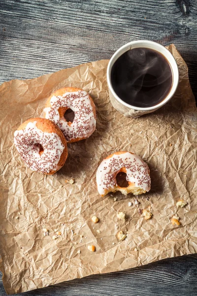 Warme koffie en donuts op papier — Stockfoto