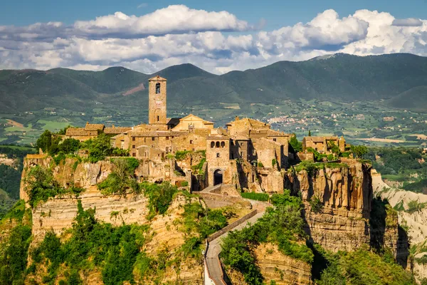 Starożytne miasto na wzgórzu w Toskanii, na tle góry. — Zdjęcie stockowe