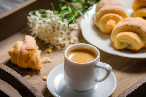 Frukost till sängs med varmt kaffe och blommor — Stockfoto