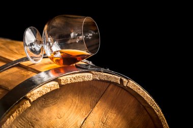 Glass of cognac on the vintage barrel clipart