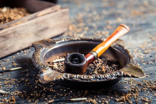 Closeup of old wooden pipe in ashtray — Stock Photo, Image