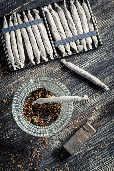 Крупный план сигарет, пепельницы и зажигалки — стоковое фото