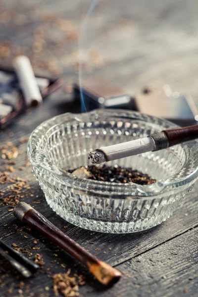 Fuming a cigarette in the old pipe — Stock Photo, Image