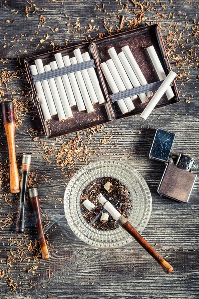 Cigarrillos, cenicero y pipa humeante — Foto de Stock